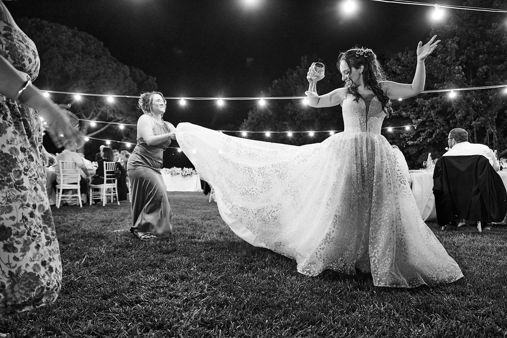 La sposa che balla sotto le luci, a tarda sera, in bianco e nero