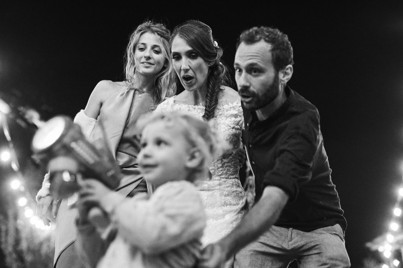 Invitati e un bambino durante la festa, in bianco e nero